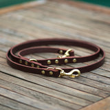 Leather and brass utility multi leash. Handmade in Australia. Displayed on a solid wooden table.